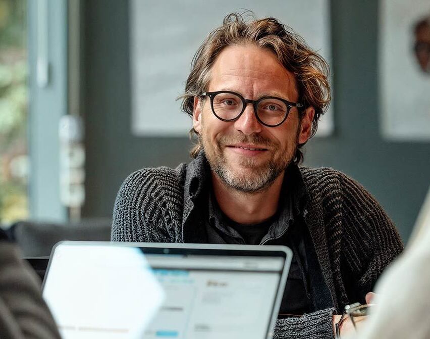 Glad mand bag bordet | AI genereret billede Glad mand bag bordet | AI genereret billede